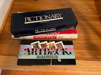 Pictionary, Monopoly and ArtDeck board games stacked