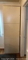 Front view of tall white cabinet closed