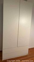 Front view of closed white two-door wardrobe with lower drawers