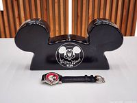 Closed Mickey-ears shaped box with logo and wristwatch in front