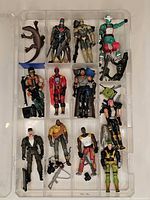 Full view of clear plastic case showing 11 action figures, reptile, accessories