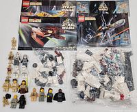 Overall lot view showing minifigures, instruction manuals, sealed bags and loose parts