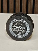 Front of puck showing Teen Ranch Foundation logo, date and signature