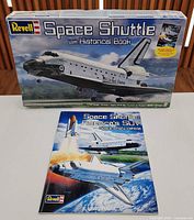 Front of boxed Revell Space Shuttle kit beside companion historical book