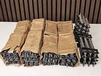 Bundles of straight track in brown wrapping and stack of curved track