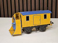 Right side view of yellow and blue Hornby O gauge snow plow car