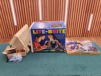 Lite-Brite unit, original box, refill kit box on table