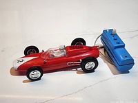 Full view of red Lotus Ford car tethered to blue controller