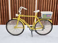 Right-side view of entire yellow Barbie bicycle with basket