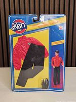 Front view of sealed Ken Fashion Basics blister card showing red quilted jacket, black pants, black shoes