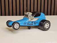 Left side profile showing blue body, decals, chrome engine, wheel configuration