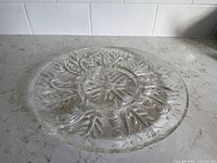 Top view of entire clear glass platter showing leaf design and central recess