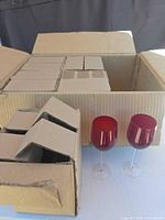 Master box open showing individual inner boxes and two example red wine glasses