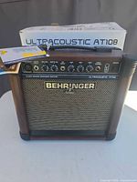 Front view of Behringer Ultracoustic AT108 amplifier with tag and box