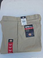 Folded Dickies khaki work pants with tags visible