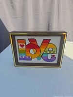 Front view of framed needlepoint LOVE art