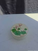 Cyclamen floral design on lid of storage tin