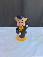 Front view of Fifer Pig coin bank showing full figure, fiddle, base lettering