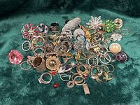 Pile of assorted costume rings on green fabric