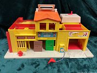 Front view of Play Family Village showing police station, barber shop, gas station and accessories