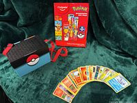 Gift pack, carry case, fanned Pokémon cards on green cloth
