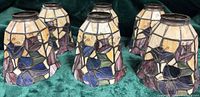 Six stained glass lamp shades grouped to show overall quantity and design