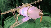Overall view of glass and acrylic biplane lamp lit