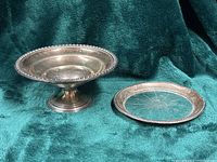 Sterling pedestal candy dish alongside crystal dish front view