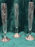 Front view of three crystal vases with silver bases