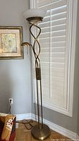 Full view of torchiere lamp showing twisted stem, base, uplight bowl, reading arm