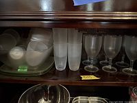 Cabinet view showing frosted bowls, plate, tumblers and goblets