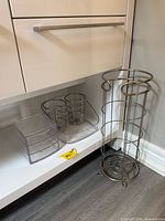 All three bathroom organizer pieces: wire toilet paper holder, acrylic drawer unit, plastic tray with cup holders