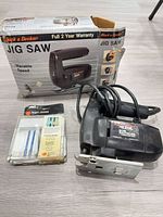 Jig saw with cords, blade pack and box displayed together