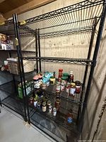 Front view of the black metal wire shelving unit showing all five adjustable shelves.