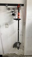 Full view of Black+Decker cordless trimmer hanging on wall