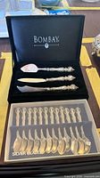 Boxed set showing Bombay branding with three serving pieces and twelve spoons