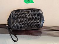 Front view of Coach black ruched leather wristlet