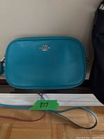 front of Coach turquoise crossbody bag