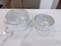 Square and round CorningWare casseroles with lids in place