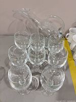 Set of eight wine glasses arranged around clear glass decanter