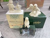 Overview of three Snowbabies figurines with their boxes