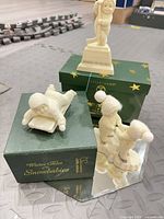 Overview showing three Snowbabies figurines, mirror base, and boxes