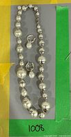 Full view of necklace and both earrings laid flat