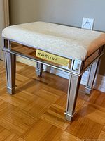 Full view of vanity bench showing mirrored panels, upholstered seat, size label
