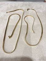 overall view of two necklaces and bracelet laid flat