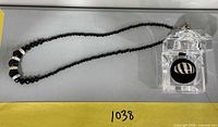 Full view of black bead necklace with pendant and ring in display box