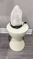 Salt lamp sitting on plastic pedestal side table