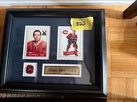 Front view of framed plaque showing two card prints, enamel pin and nameplate