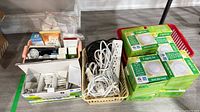 Three baskets containing LED panel light boxes, bulbs, power strip and cords
