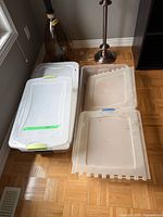 Three storage totes on floor: one closed, two lids removed